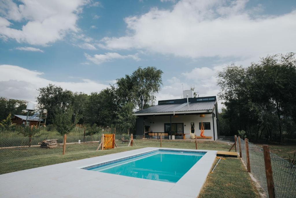 una casa con piscina frente a ella en Casa Brunia Lago Los Molinos en Villa General Belgrano