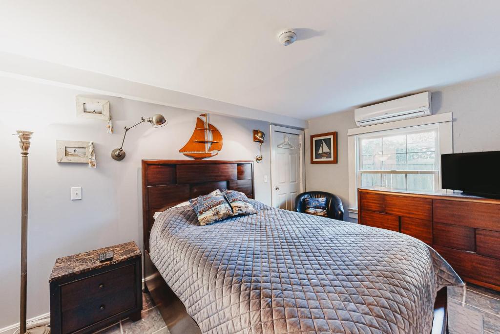 1 dormitorio con 1 cama y TV. en Captivating Cottage, en Provincetown