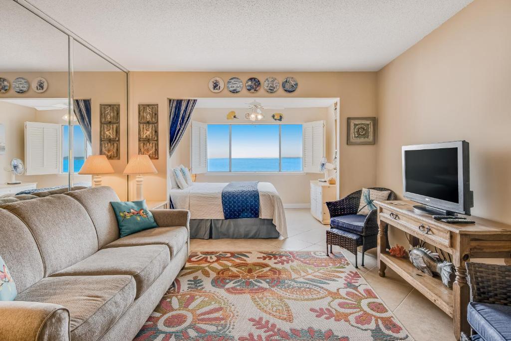 uma sala de estar com um sofá e uma televisão em Sunset Harbor Palms 1-204 em Navarre
