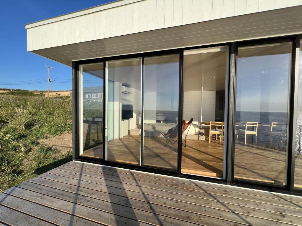 a house with large glass windows on a deck at Cliff House MORAI - Vacation STAY 14408 in Ishikari