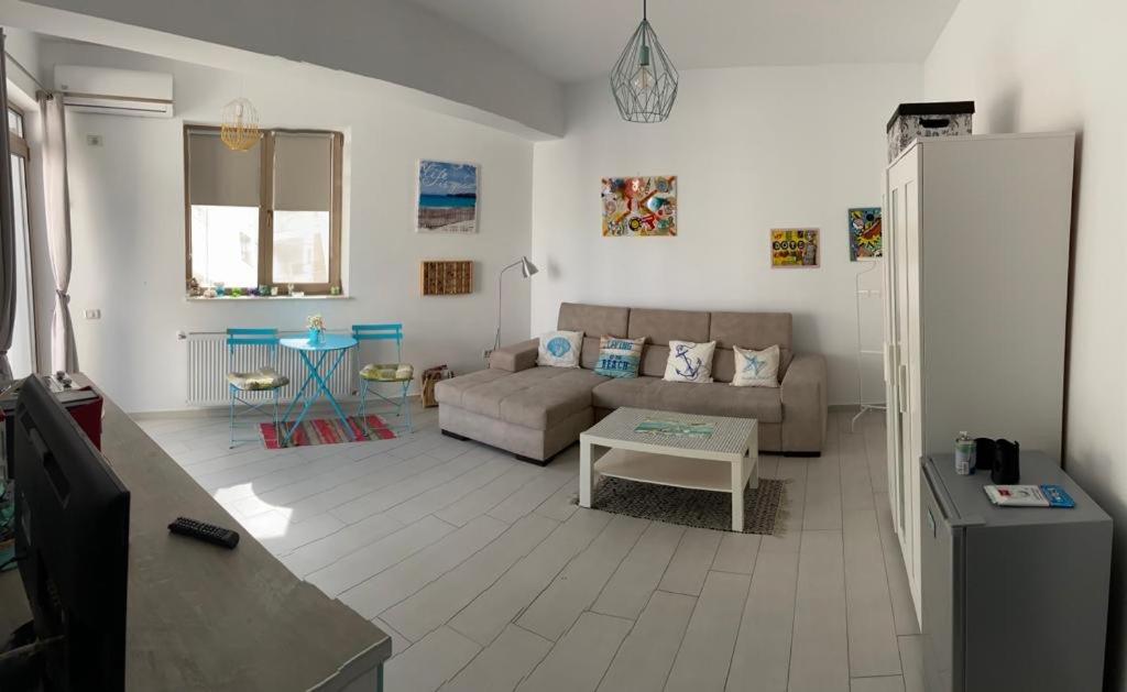 - un salon avec un canapé et une table dans l'établissement Azzurro Sea View Mamaia, à Mamaia