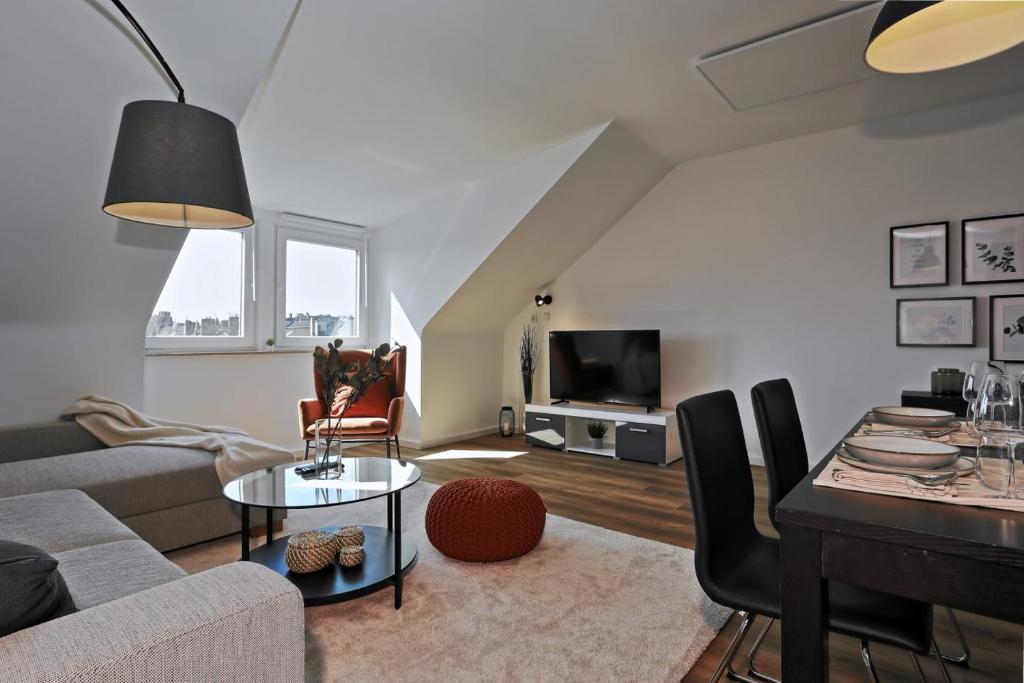 a living room with a couch and a table at Stylish 3BR apartment -10min to Hbf, full kitchen, homeoffice, Netflix, Wifi in Düsseldorf