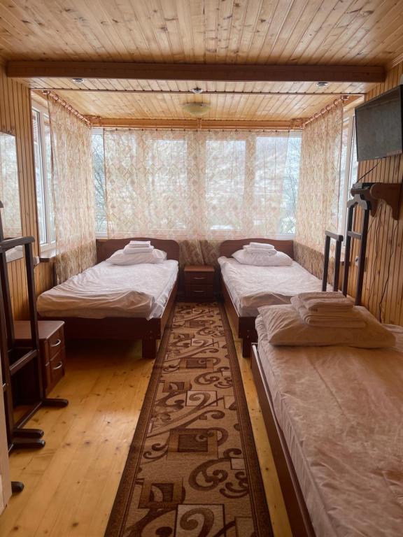 um quarto com 3 camas num quarto com um tapete em Made in Yaremche em Yaremche