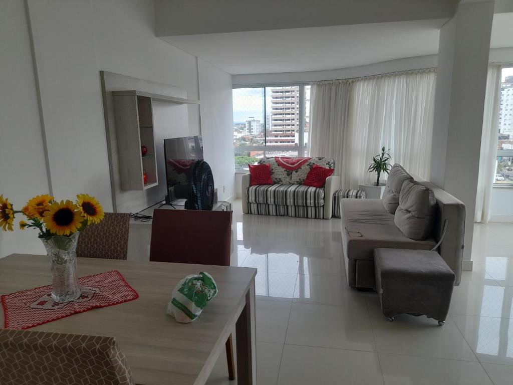 uma sala de estar com um sofá e uma mesa em Confortável apartamento na praia em Capão da Canoa