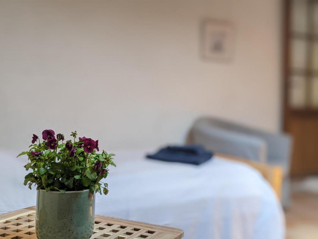 un vase avec des fleurs sur une table dans une chambre dans l'établissement La Grange Vercors, à Les Maillets