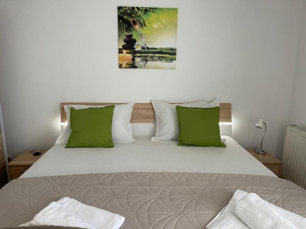 um quarto com uma cama grande e almofadas verdes em Relaxing Bucharest Airport Residences & Therme-SELF CHECK-IN em Otopeni