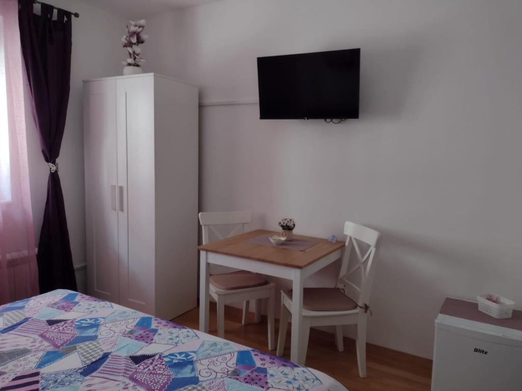 mały pokój ze stołem i telewizorem na ścianie w obiekcie Room Armani w Rovinj