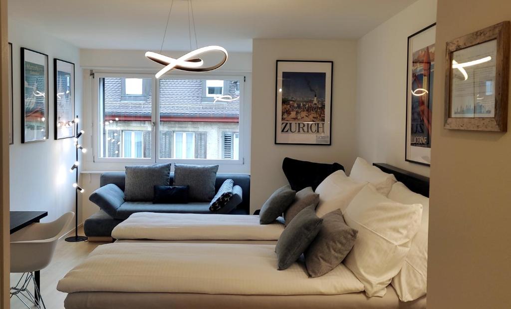 ein Wohnzimmer mit 2 Betten und einem Sofa in der Unterkunft Seven Swiss Wonders, City Center in Zürich