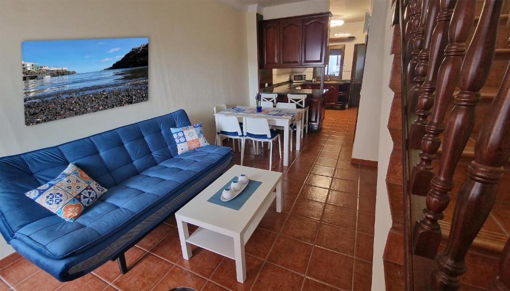 a living room with a blue couch and a table at Descubre el encanto del Tamaduste en tu refugio vacacional in Tamaduste