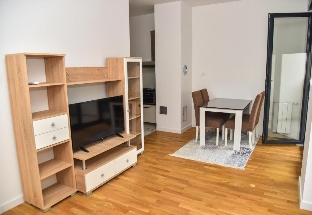 een woonkamer met een bureau, een tafel en een televisie bij Apartment Banja Luka, Park in Banja Luka