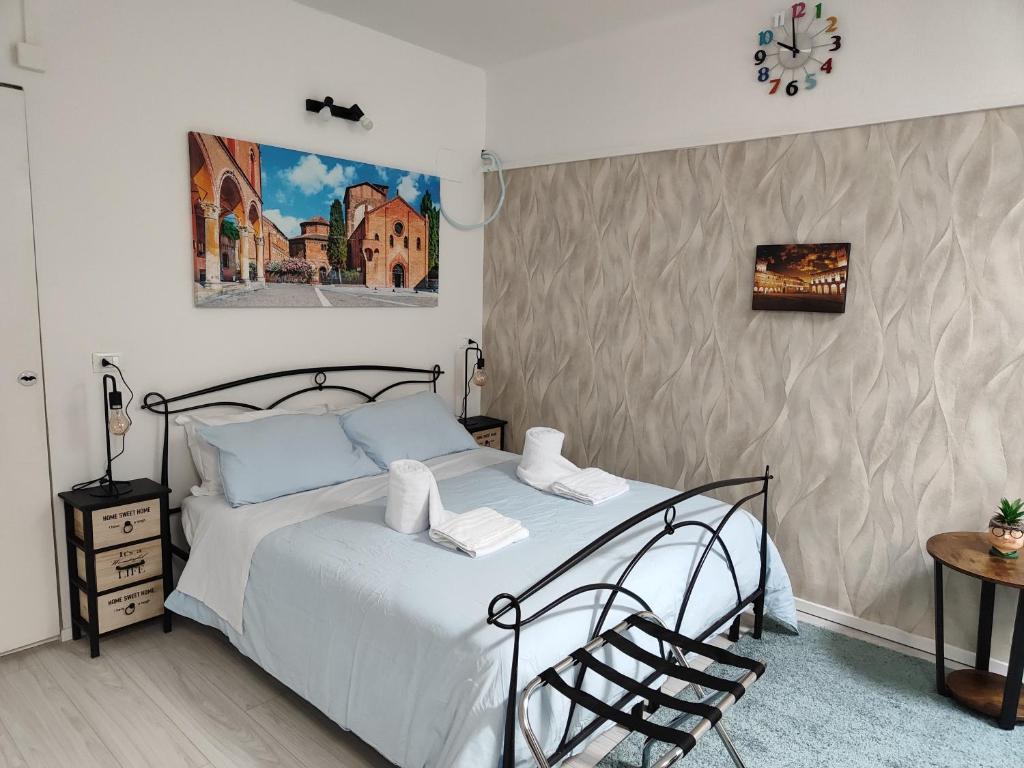 ボローニャにあるResidenza le Torriのベッドルーム1室(ベッド1台付)が備わります。壁には絵画が飾られています。