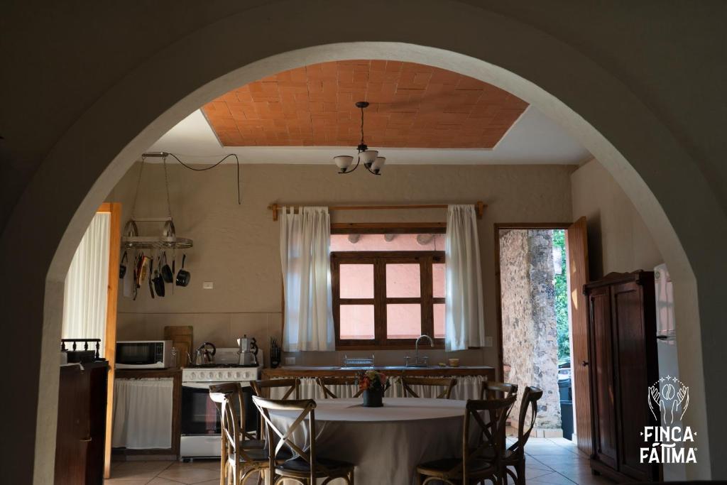 a kitchen with a table with chairs and an archway at Cabaña en cafetal de Coatepec in Coatepec