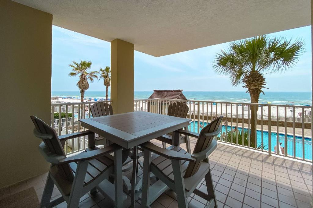 une table et des chaises sur un balcon avec vue sur l'océan dans l'établissement Romar Place 202, à Romar Beach