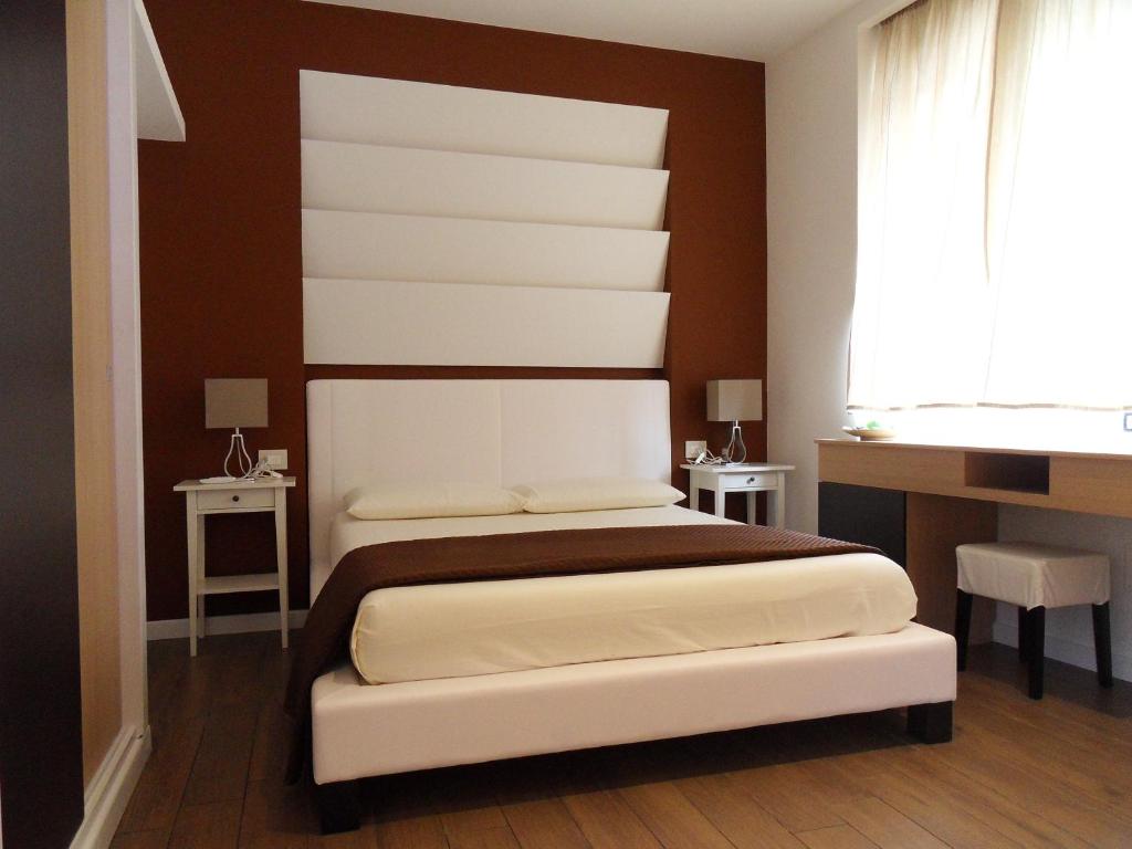 a bedroom with a bed and two tables and a window at Conchiglia Suite in Margherita di Savoia