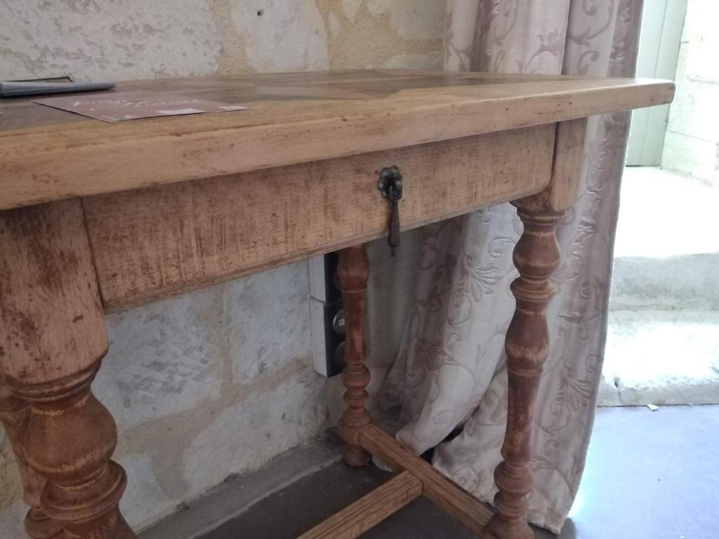 drewniany stół z drewnianym dachem na drewnianym stoliku w obiekcie Gîte Brilhac w mieście Monts-sur-Guesnes