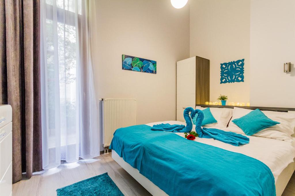ブダペストにあるBlue Magic Apartmentのベッドルーム1室(青い毛布付きのベッド1台付)