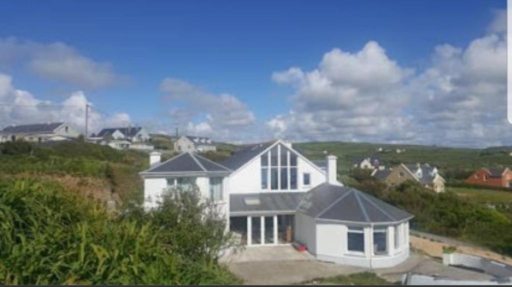 a white house sitting on top of a hill at Wild Atlantic Lodge Bed & Breakfast in Lahinch