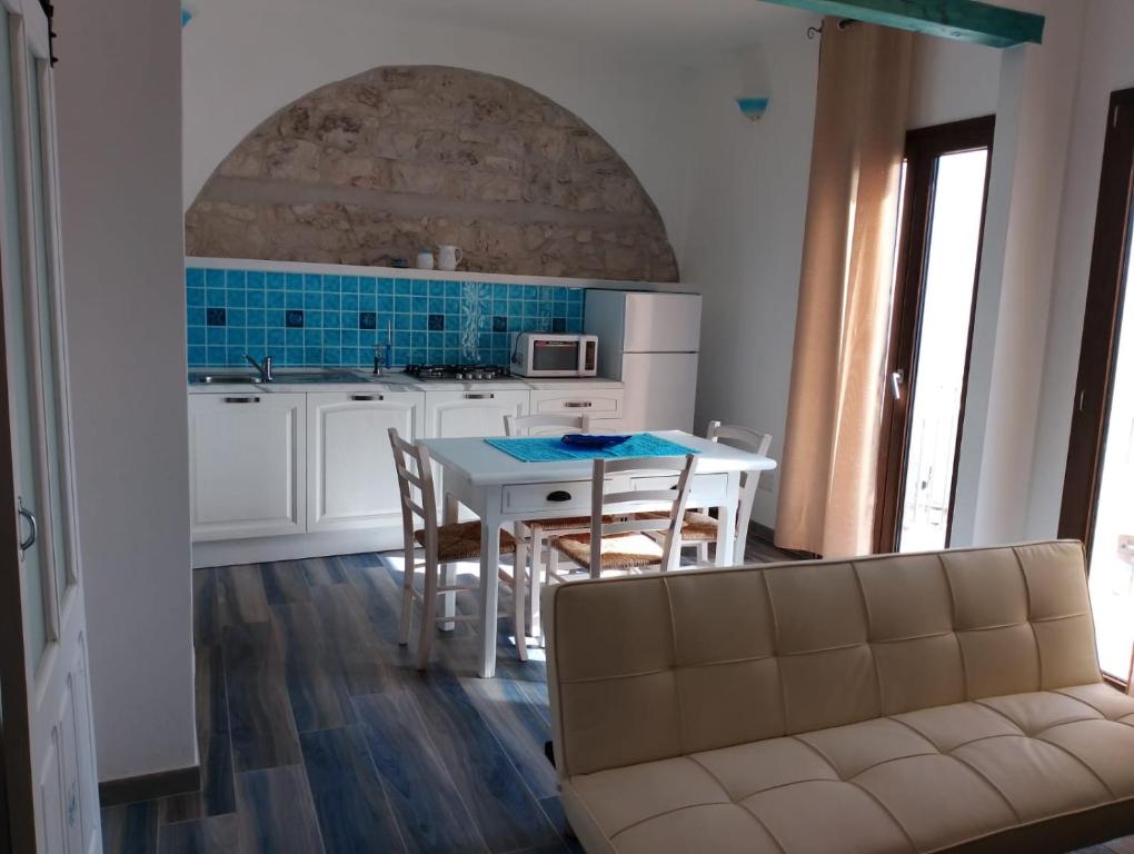 una cucina con tavolo bianco e piastrelle blu di Sa Dommu de Kerciu vista mare IUN R0018 a Baunei