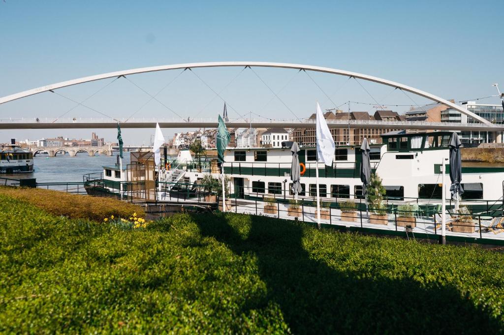 a bridge over a river with boats on the water at Botel Maastricht in Maastricht