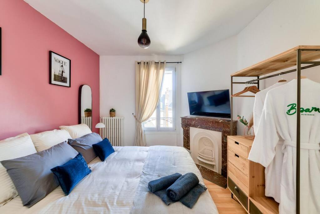 a bedroom with a large bed and a tv at Fibre - Le Haussmann LH - B'PAM in Le Havre