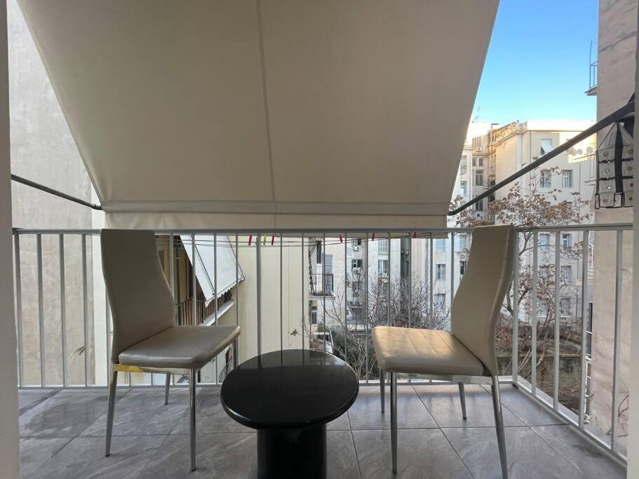 two chairs and a glass table on a balcony at ATH Luxury Central apartment in Athens