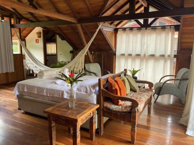 a bedroom with a hammock bed and a table and chairs at Pousada. Espatódea in Petrópolis