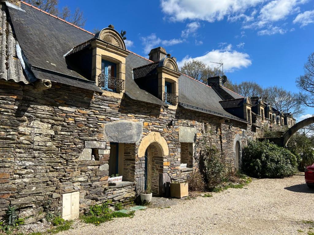 stary kamienny budynek z dachem w obiekcie La Ferme de Roulotte de Sandrine w mieście Carentoir