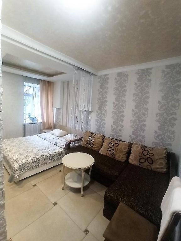 a bedroom with a bed and a couch and a table at Готель Жасмин in Ternopil