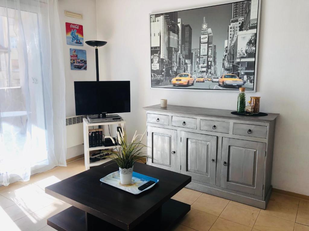 a living room with a tv and a coffee table at Le Californie Plage Carras in Nice
