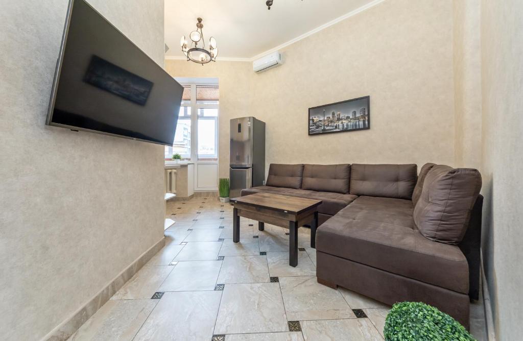 a living room with a couch and a flat screen tv at Khreschatyk. Maidan, Independence Square 2BR in Kyiv
