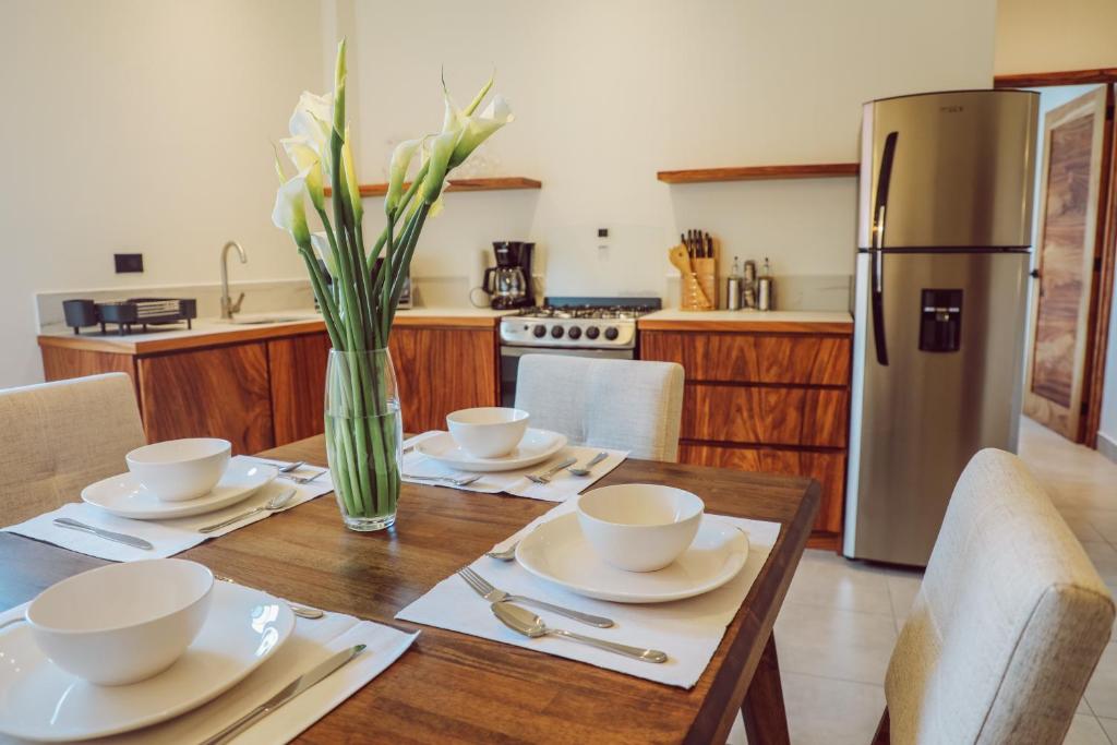 uma cozinha com uma mesa de madeira com cadeiras e um frigorífico em Lahos Apartament B em Panajachel