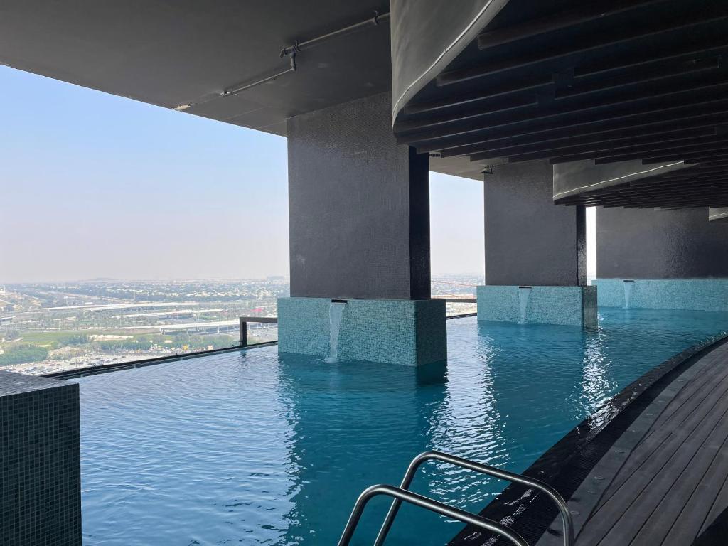 a swimming pool with a chair in the water at Luxury 1 bedroom apartment in Miraclz tower by Danube Properties in Dubai