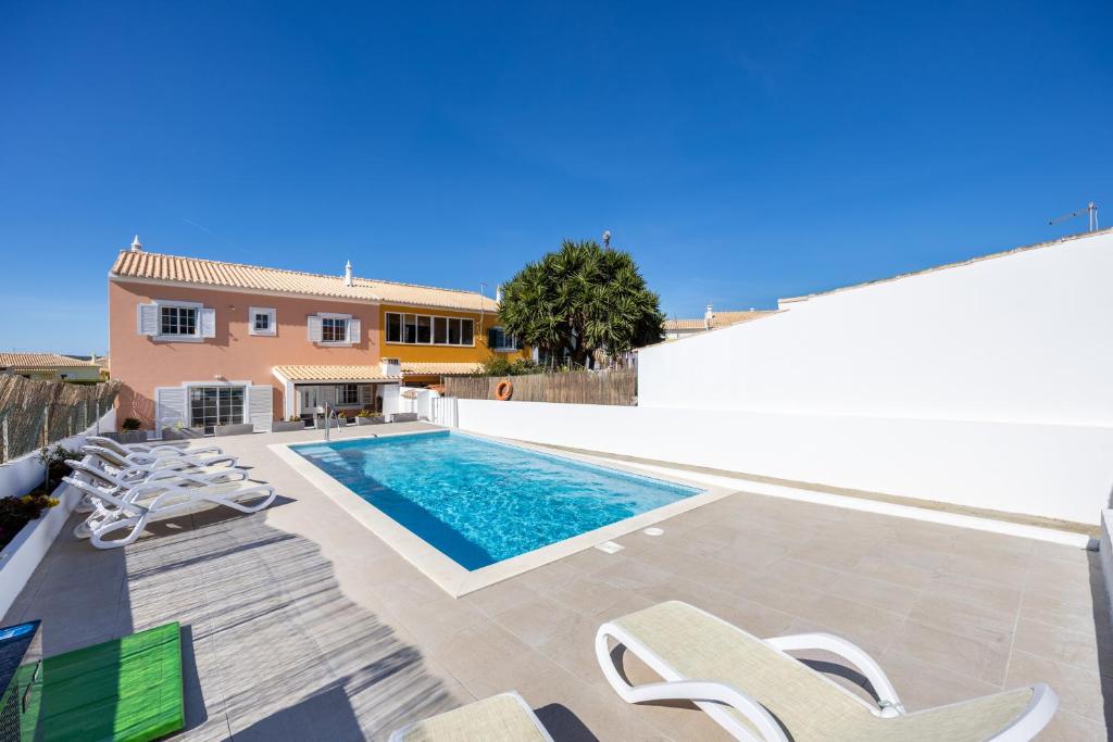 una villa con piscina y tumbonas en Sweet Home Sagres, en Sagres