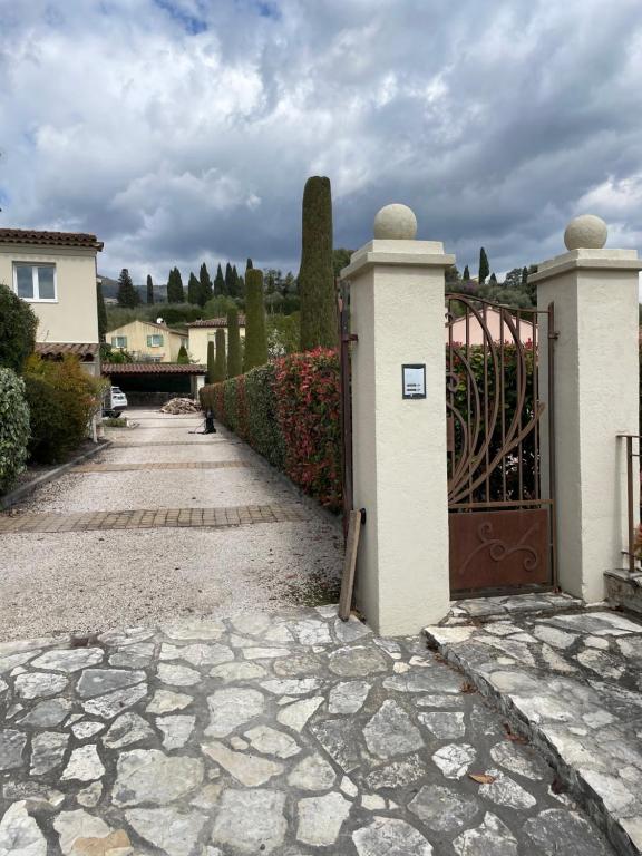 a gate to a house with a stone driveway at Gîte des Restanques in Grasse