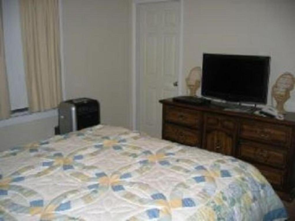 a bedroom with a bed and a television on a dresser at Pine Tree Inn in Panaca