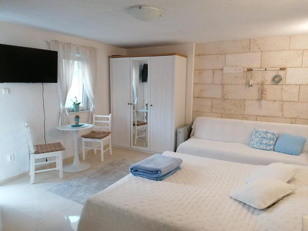 uma sala de estar branca com um sofá e uma cama em Apartmán BRAĆKI CVIJET em Sutivan
