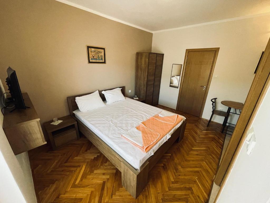 um quarto com uma cama e piso em madeira em Apartments Near Portonovi em Ðenovići