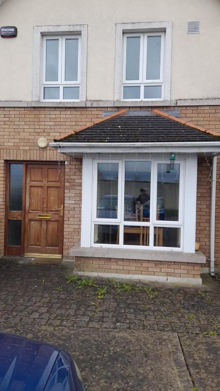 een huis met een groot raam en een houten deur bij Hawthorn Walk in Kilkenny