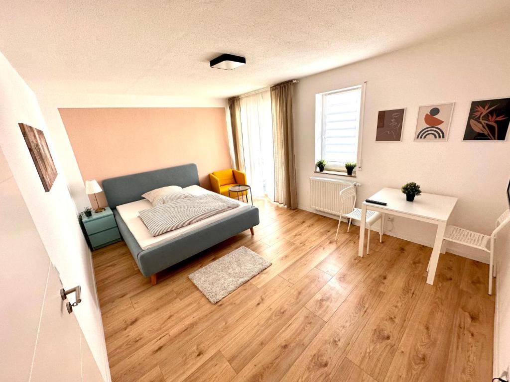 Schlafzimmer mit einem Bett, einem Tisch und einem Fenster in der Unterkunft Business Apartment Lörrach in Lörrach