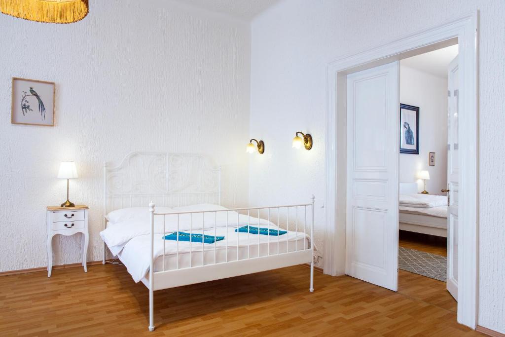 um quarto branco com uma cama branca e um espelho em Large 3 BDR APT in the heart of Prague em Praga