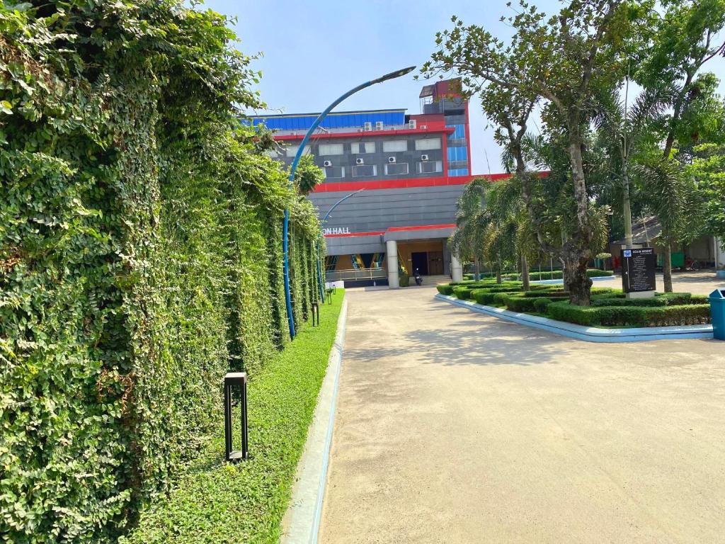 a hedge in front of a building next to a street at CCULB Resort & Convention Hall in Gazipur