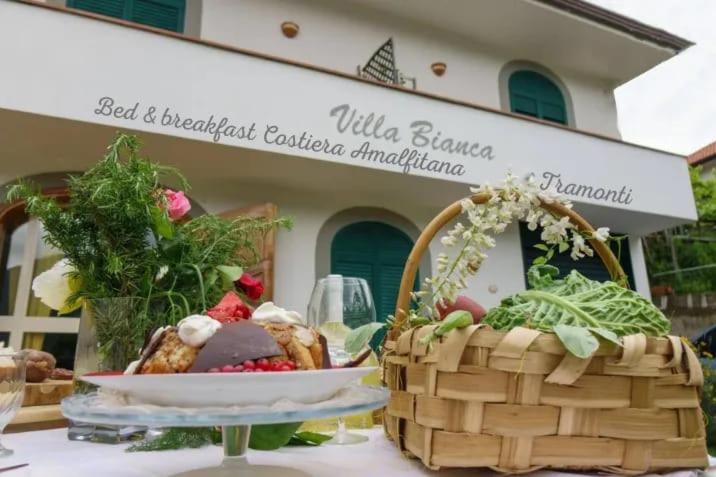 un tavolo con un cesto di cibo e un piatto di cibo di Villa Bianca a Tramonti