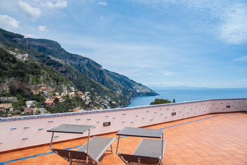 un gruppo di sedie su un balcone con vista sull'oceano di YourHome - Lorena Maria House Positano a Positano