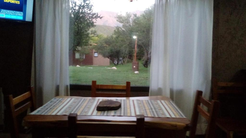 einem Holztisch vor einem Fenster in der Unterkunft Naure Casas Serranas in Quebrada de los Pozos