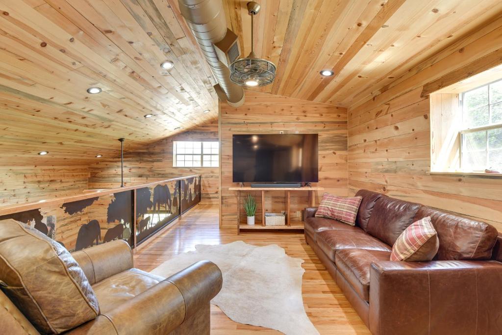 uma sala de estar com um sofá e uma televisão de ecrã plano em Early Cabin with Deck about 20 Mi to Lake Brownwood! em Early