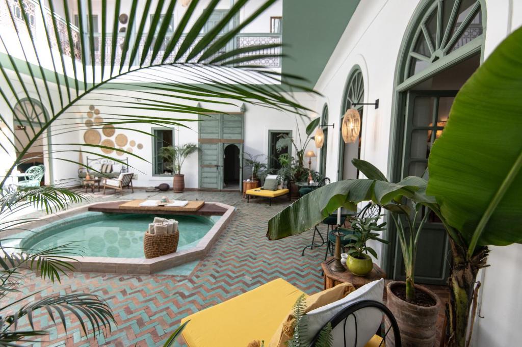 un patio interior con piscina y plantas en Riad Agathe & Spa, en Marrakech