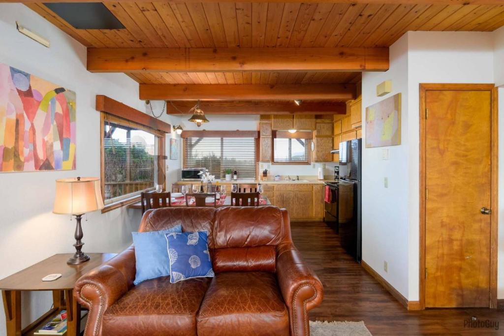 a living room with a leather couch and a kitchen at Pacific Lookout in Florence