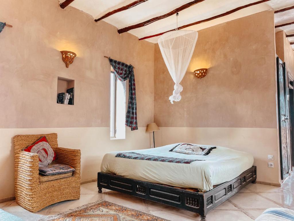 a bedroom with a bed and a chair at LE BLED DE GRE in Marrakech