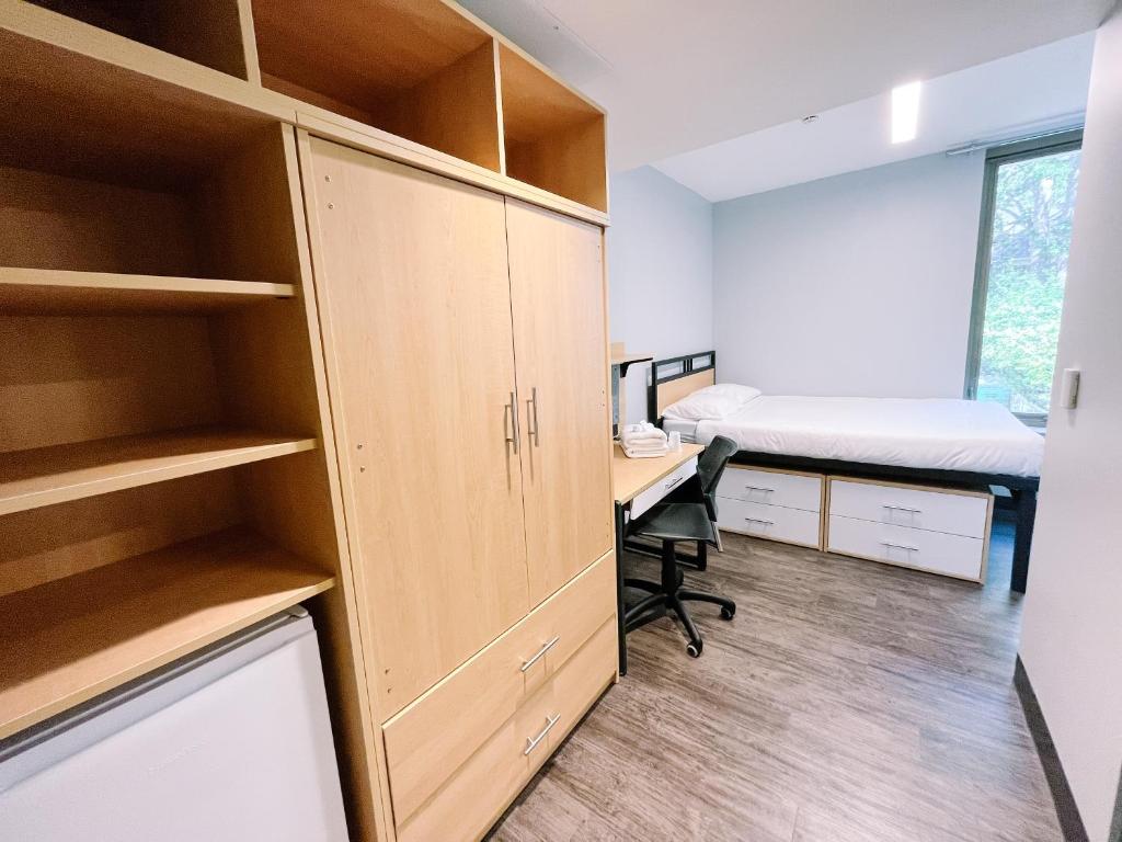 1 dormitorio con escritorio y 1 cama en una habitación en Queen's University Residence en Kingston