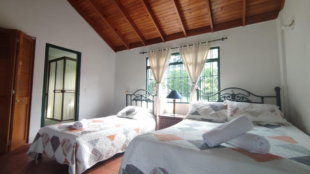 a bedroom with two beds and a window at New Paradise Casa Campestre in Villeta